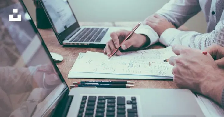 Bureau épuré avec carnet de budget et lumière sable.